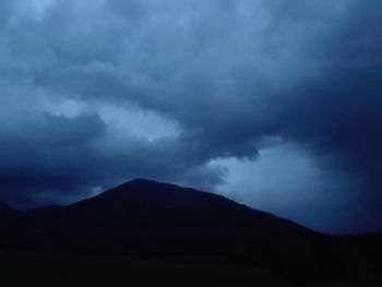 Silhouette of mountain against cloudy sky