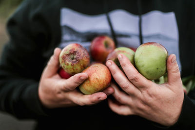 Midsection of man holding fruit