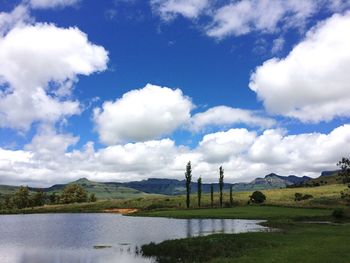 Scenic view of lake and mountains against cloudy sky