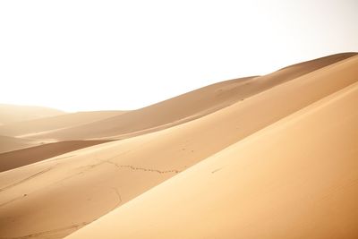 Idyllic shot of sand dunes against clear sky