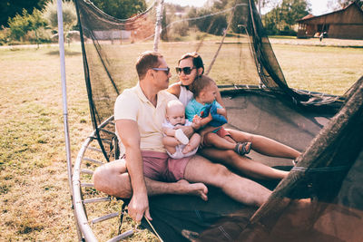 Full length of father with daughter sitting outdoors