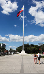 Flag against sky in city