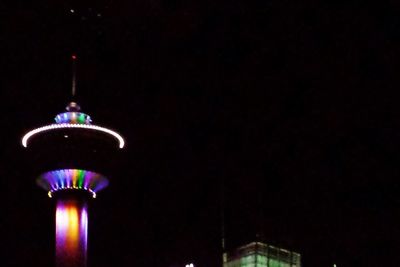 Low angle view of illuminated tower at night