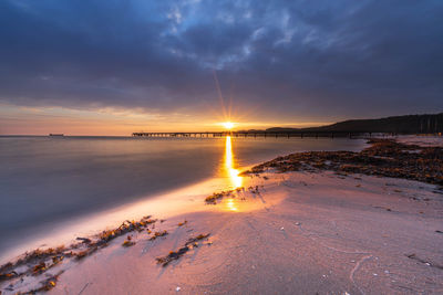 Scenic view of sea against sky during sunset with pier