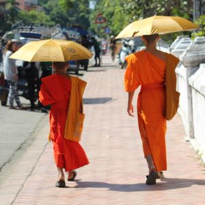 Rear view of people walking on cross