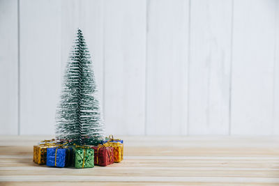 Close-up of christmas tree on table against wall