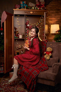 Portrait of young woman sitting on sofa at home