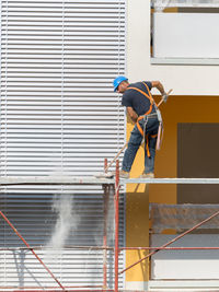 Low angle view of man working on building