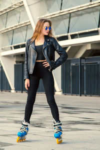 Full length portrait of young woman standing outdoors