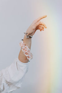 Close-up of woman holding hands over white background