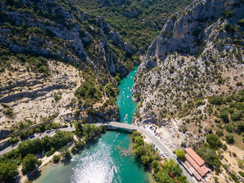 Aerial view of bridge over river flowing amidst rock mountains