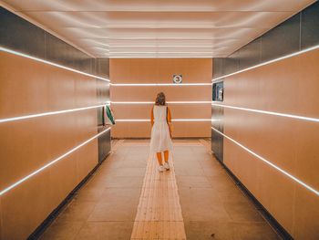 Rear view of woman standing in corridor