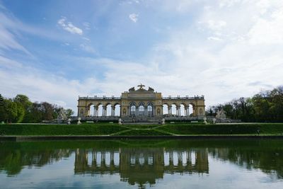 Schonbrunn palace reflecting in lake against sky