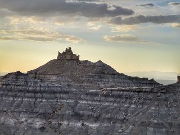 Castle on mountain against cloudy sky