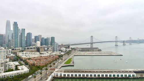 High angle view of suspension bridge and buildings against sky