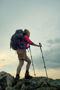 Low angle view of hiker on rocky mountain