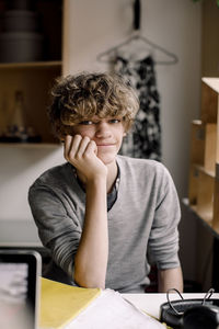 Portrait of boy sitting on table