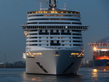 Illuminated ship in sea against clear sky at night