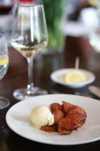 Close-up of dessert served in plate with wine on table