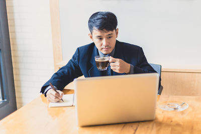 Mid adult man using laptop on table