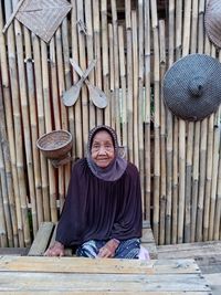 Portrait of smiling young woman sidown by table