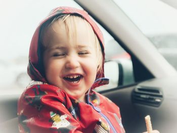 Portrait of cute smiling girl sitting in car