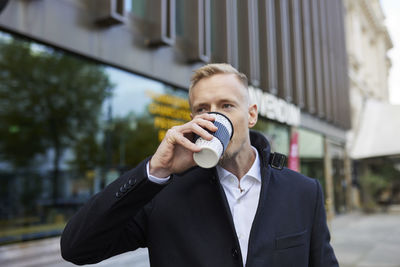 Businessman drinking takeaway coffee outdoors