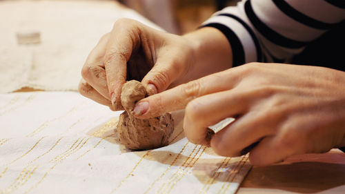 Cropped hand of woman preparing food on table