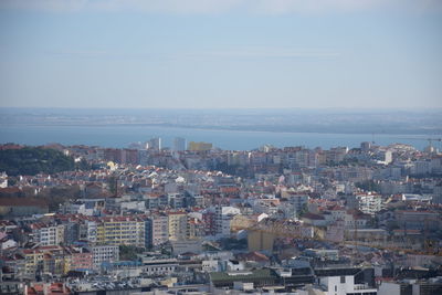 High angle view of townscape by sea against sky