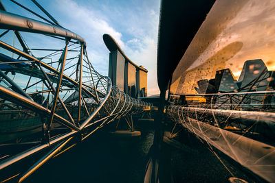 Bridge over illuminated ferris wheel against sky