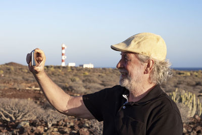 Portrait of man photographing hat