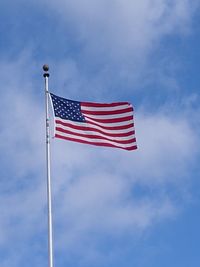 Low angle view of flag against blue sky