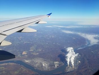 Close-up of airplane wing against sky