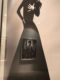 Man standing by statue against wall