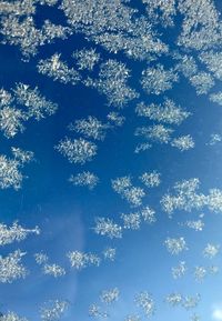 Full frame shot of snowflakes on blue sky