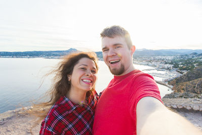 Portrait of smiling young couple at beach