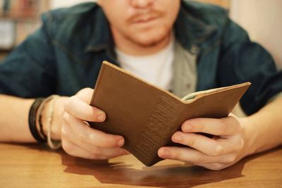 Midsection of person holding book