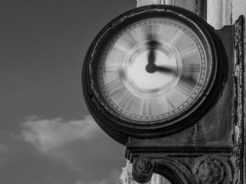 Low angle view of clock against sky