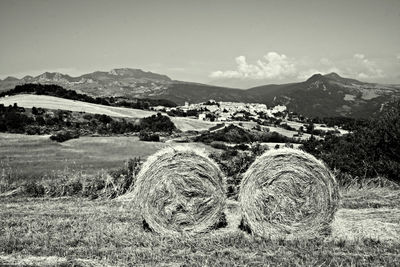 Hay bales on field against sky