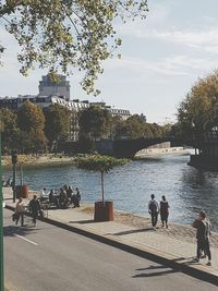 People on shore against sky