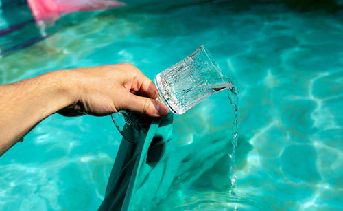 Midsection of man drinking water in swimming pool