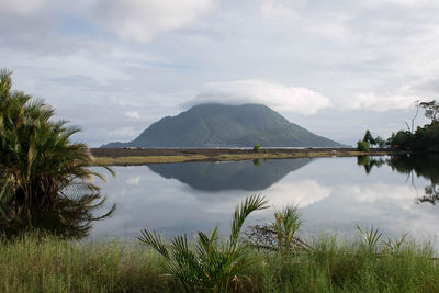 Scenic view of lake by mountains against sky