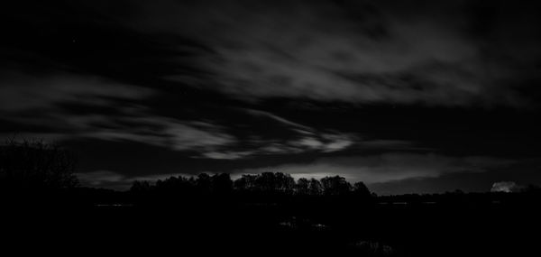 Silhouette trees against sky at dusk