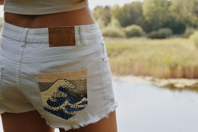 Rear view of woman standing by lake