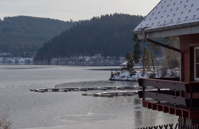 Scenic view of house by mountains during winter