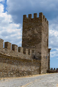 Low angle view of historic building against cloudy sky