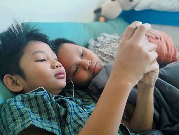 Two sons watch smart phones in the bedroom