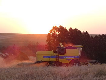 Scenic view of agricultural field against clear sky during sunset