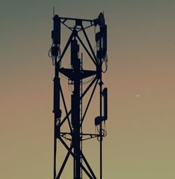 Low angle view of silhouette telephone pole against sky