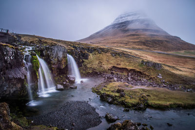 Scenic view of waterfall against sky